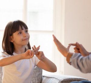 Ein Mädchen kommuniziert mit einer Frau mit Hilfe der Gebärdensprache