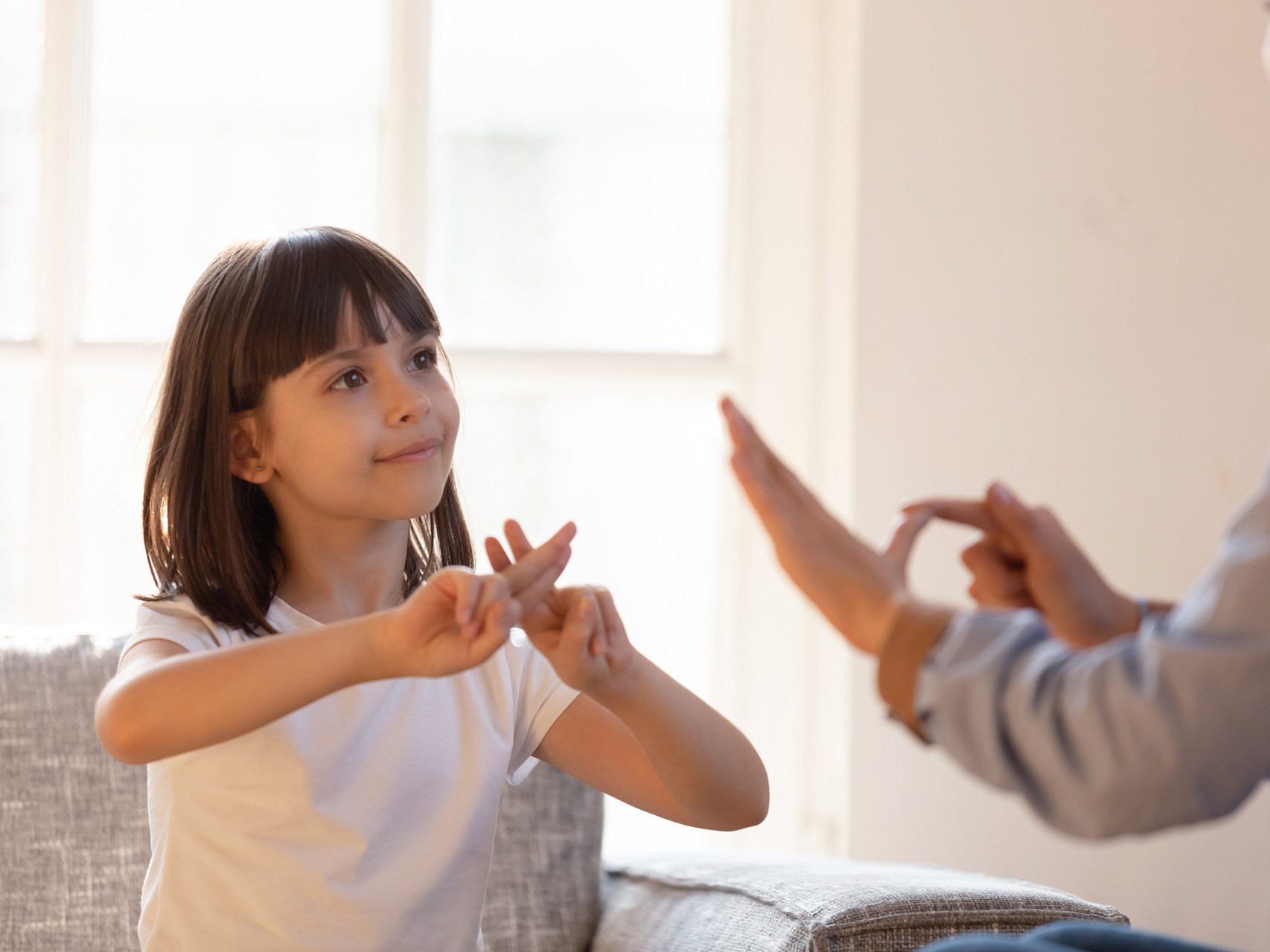 Ein Mädchen kommuniziert mit einer Frau mit Hilfe der Gebärdensprache